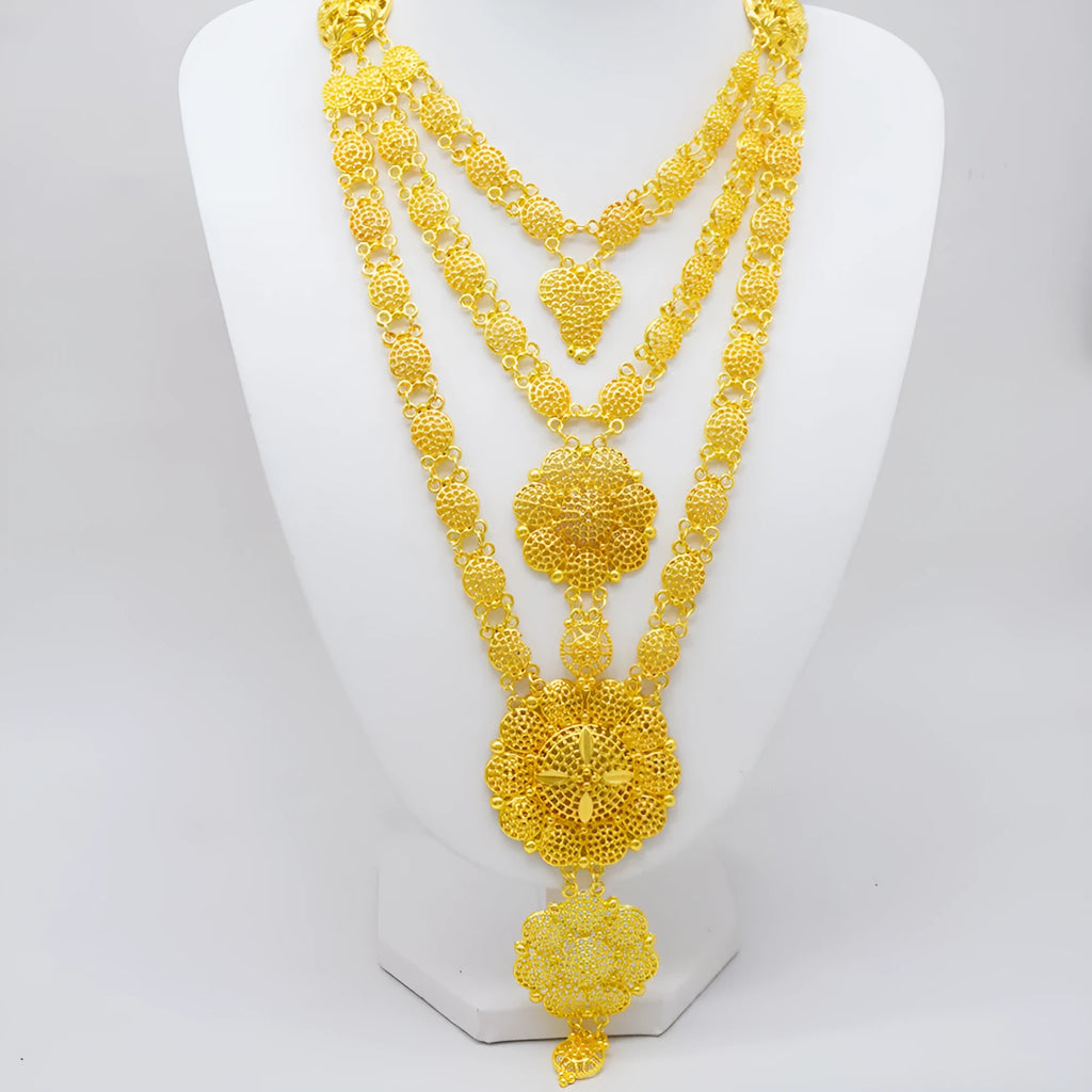 Gold women's jewellery set with tassel necklace, water wave chain, earrings, bracelet, and ring on display