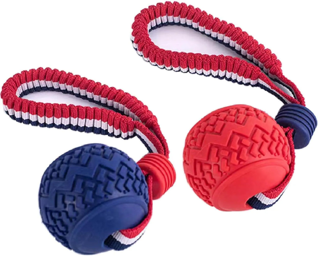 Blue dog toy with a textured rubber ball attached to a cotton rope, shown on grass.