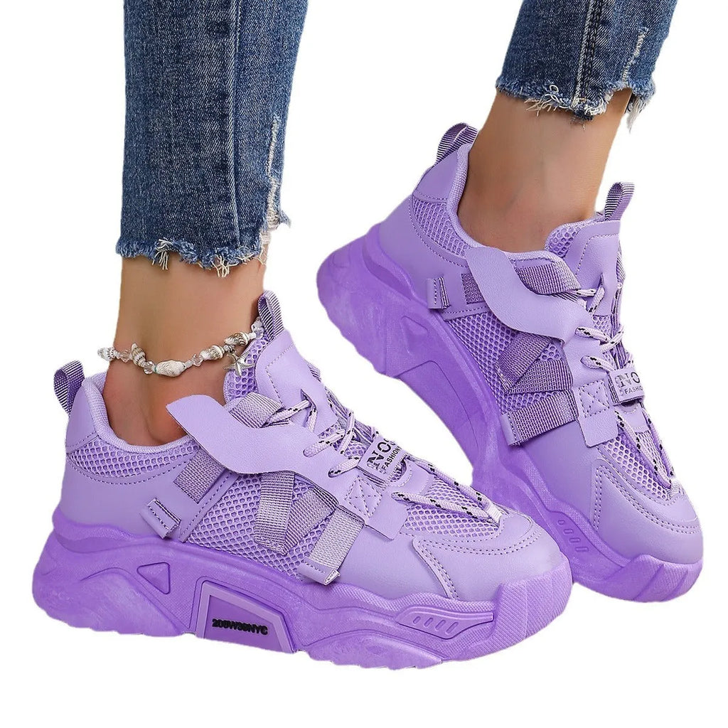 Women's purple and white platform mesh sports sneakers with front lace-up design on a plain background.
