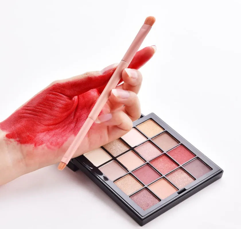 Ten cosmetic makeup brushes with wooden handles arranged showing various brush head shapes and sizes