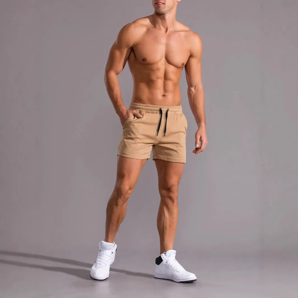 Three pairs of men's solid colour drawstring shorts in black, khaki, and light brown laid flat.