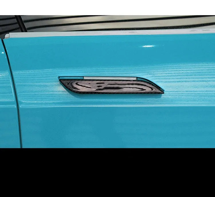 Four carbon fibre adhesive door handle protection patches for a Tesla Model S.