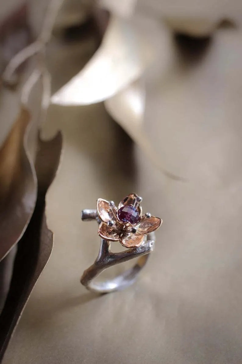 Silver two-tone floral geometric alloy ring for women on a grey background, showing detail.