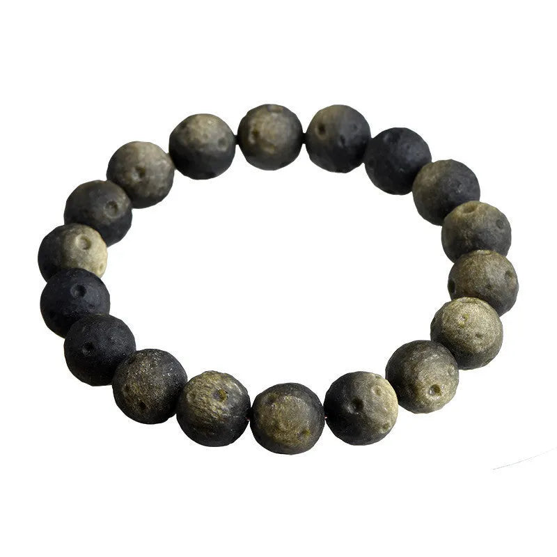 Natural obsidian crater ball bracelet in gold or silver finish on a wrist, showing textured bead detail.