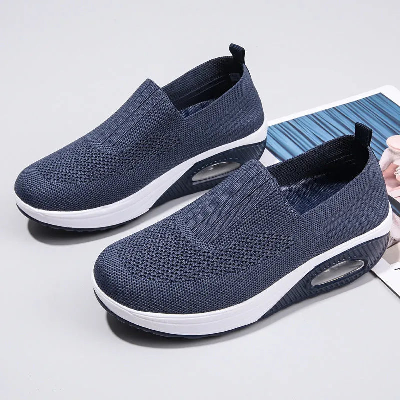 Women's beige artificial PU mesh running shoes with air cushion and round toe on a plain background.