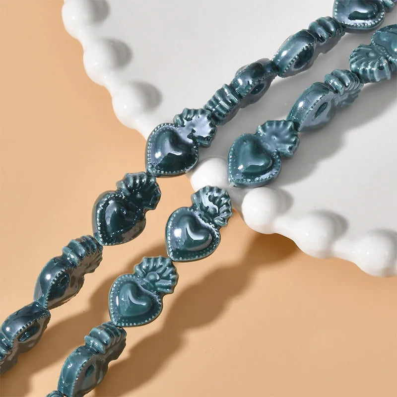 Assorted small ceramic torch beads in multiple colours on a white background.