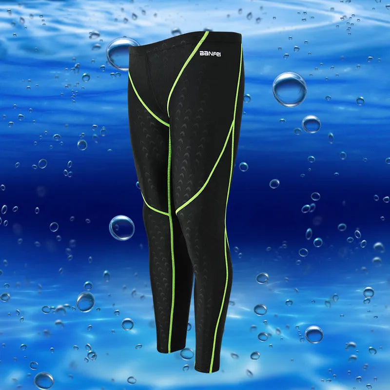 Men's nylon cropped swimming trunks in a black and green colour block design, laid flat.