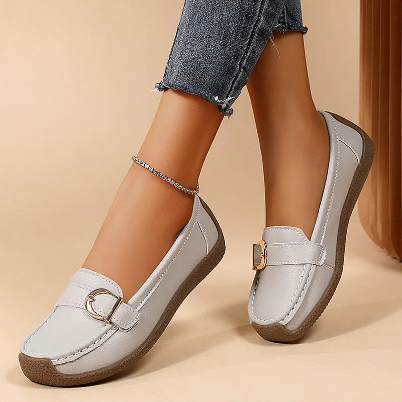 Women's beige casual loafers with round toe, flat heel, and slip-on design on a plain background.