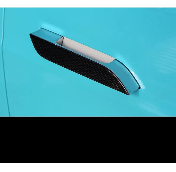 Four carbon fibre adhesive door handle protection patches for a Tesla Model S.