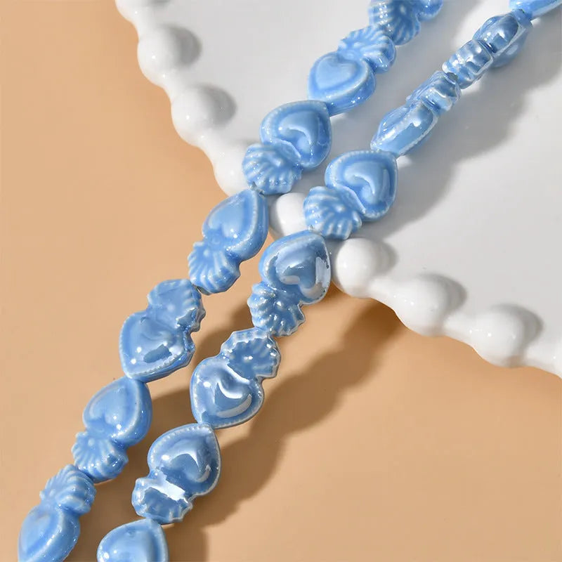 Assorted small ceramic torch beads in multiple colours on a white background.