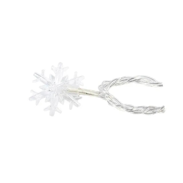 Battery powered LED snowflake string lights with star decorations lit on a dark background