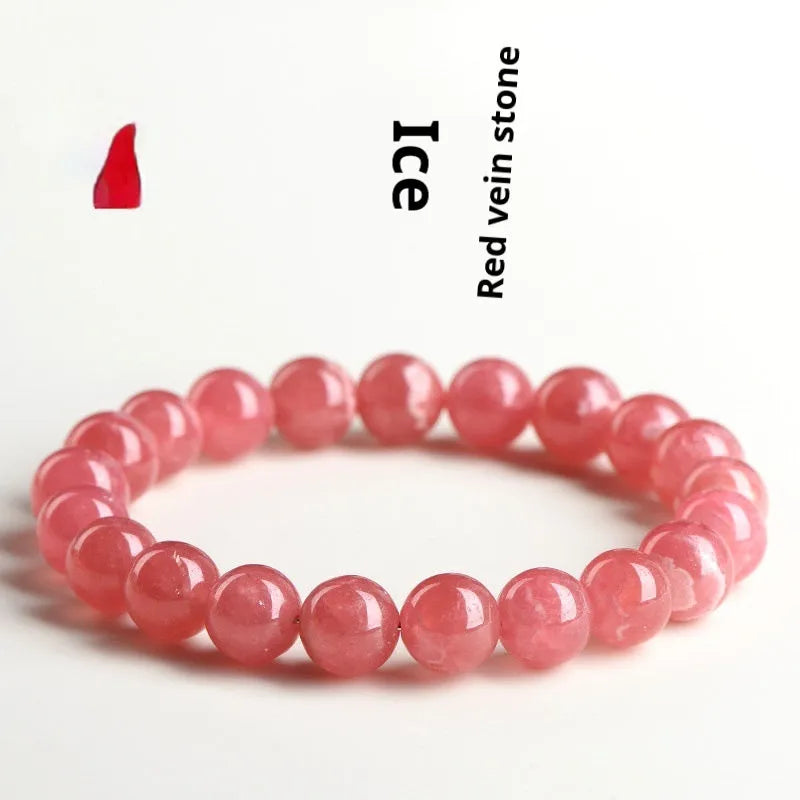 Women's red rhodochrosite crystal bracelet with geometric beads and a longevity lock clasp on a wrist.