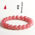 Women's red rhodochrosite crystal bracelet with geometric beads and a longevity lock clasp on a wrist.