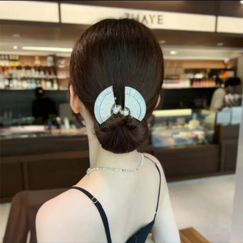 Alloy metal hair curler in fish tail style on a neutral background
