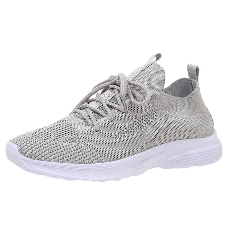 Women's low-top mesh running shoes in creamy white with Flyknit upper and rubber sole.