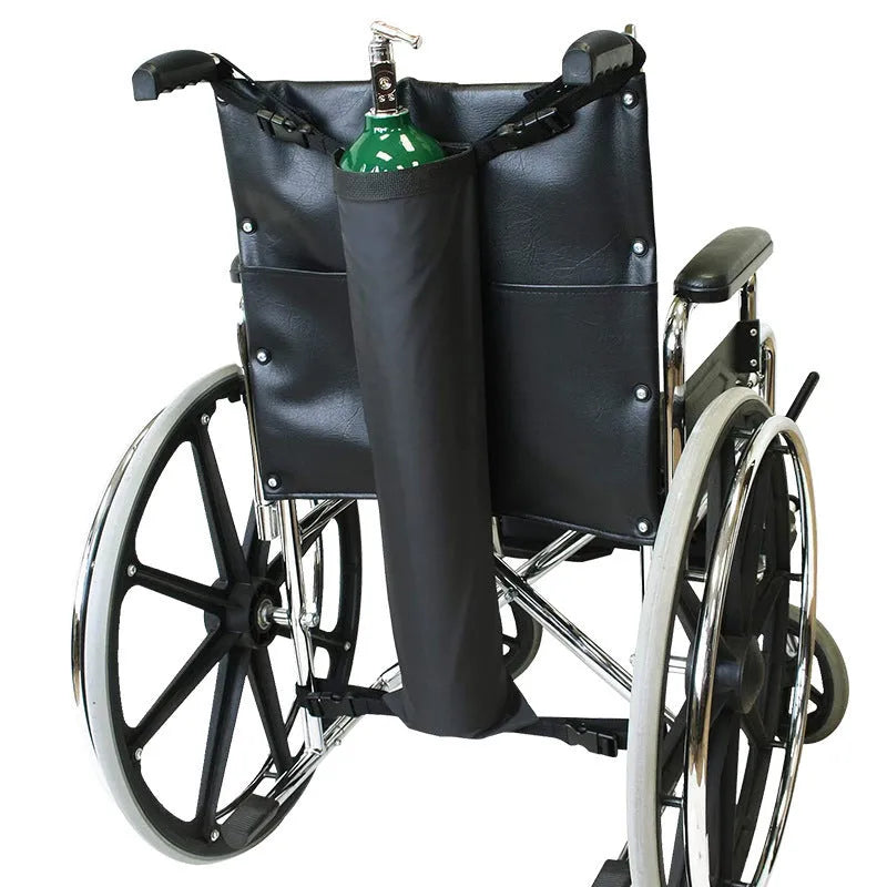 Black cylindrical outdoor pannier bag for carrying an oxygen cylinder on a wheelchair.