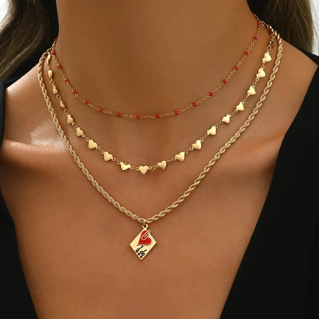 Silver-tone adjustable clavicle chain necklace with a geometric heart pendant on a three-layer chain.