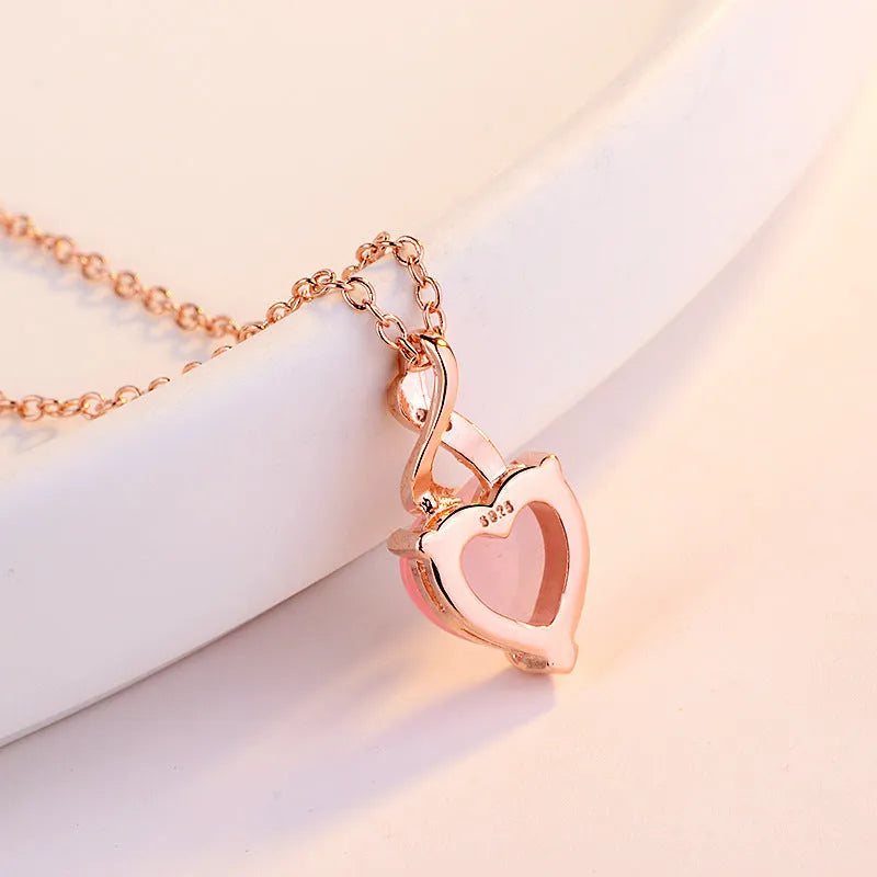 Rose gold necklace with heart-shaped pink crystal pendant and cross chain design