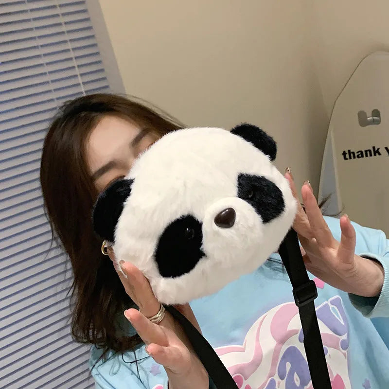 Soft plush crossbody bag with panda head design, cylindrical shape, and sandwich pocket