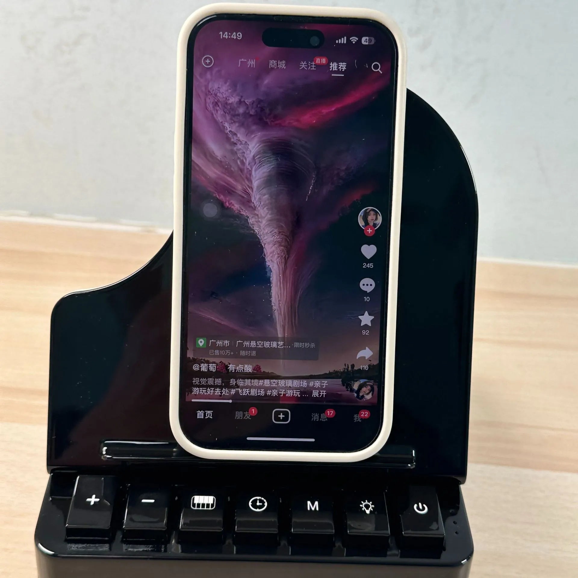 Black multi-function Bluetooth speaker with wireless charger and phone holder on a desk