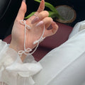White adjustable pearl necklace with bow detail measuring 31-40cm