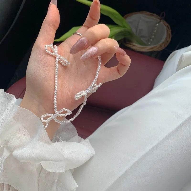White adjustable pearl necklace with bow detail measuring 31-40cm