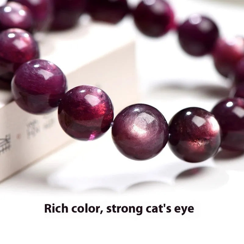 Close-up of a handcrafted purple lepidolite crystal bracelet with polished round beads on a wrist.