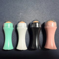 Portable volcanic stone roller for absorbing facial oil, shown in black, green, pink, and white colour options.