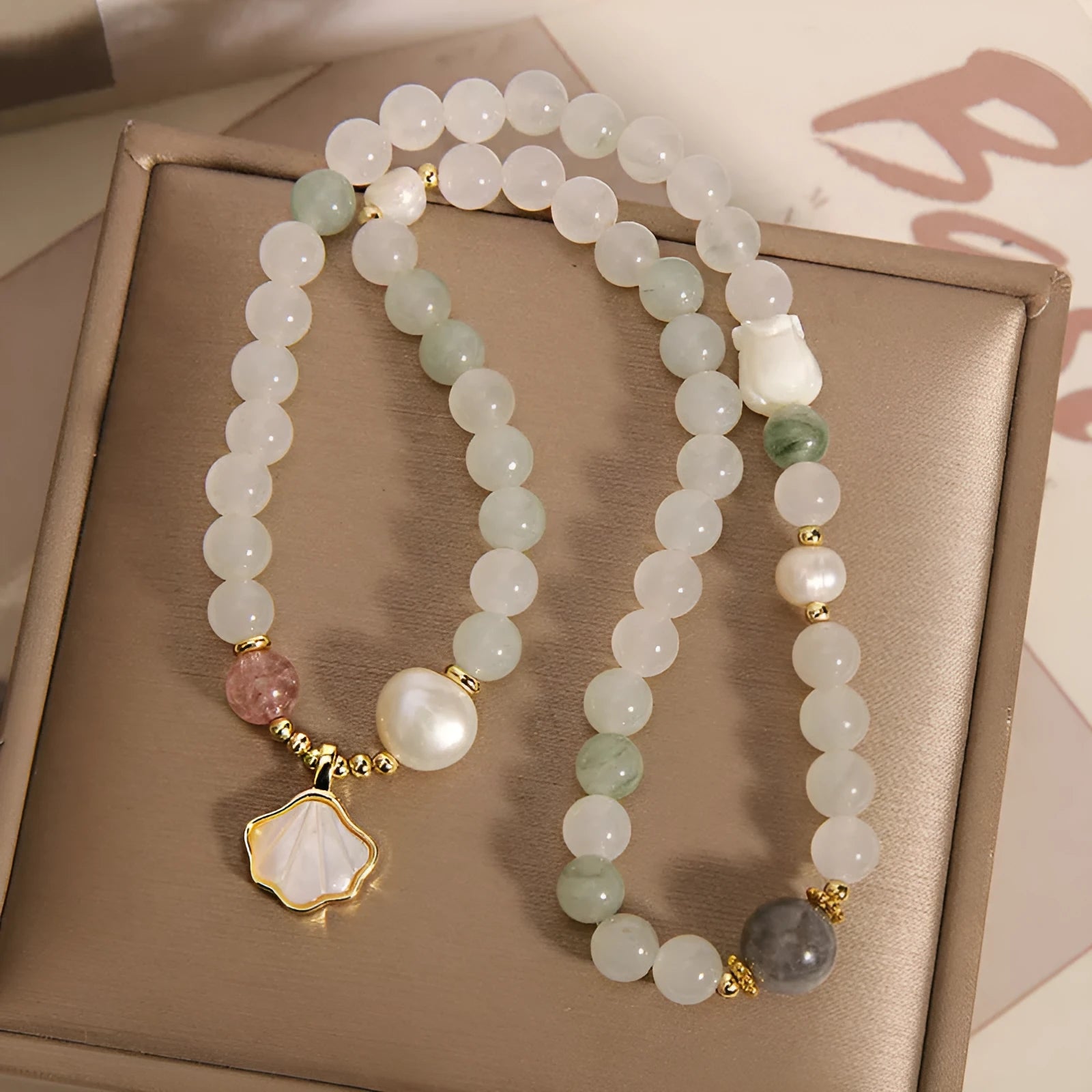 Women's crystal bracelet with gold-plated inlay, gemstones, and a Tianshan Jade ginkgo leaf pendant.