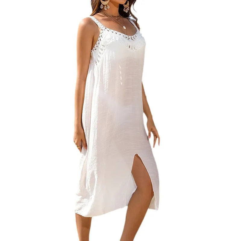 White women's beach dress with a woven crochet detail at the bottom slit on a hanger.