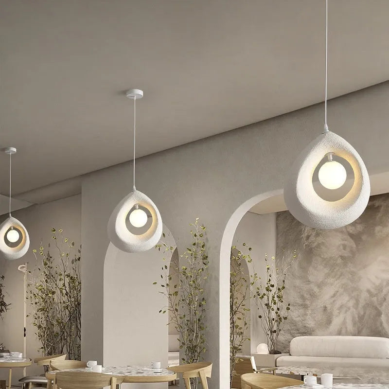 Modern pendant ceiling light with a wide milky white glass shade in a retro chandelier style.