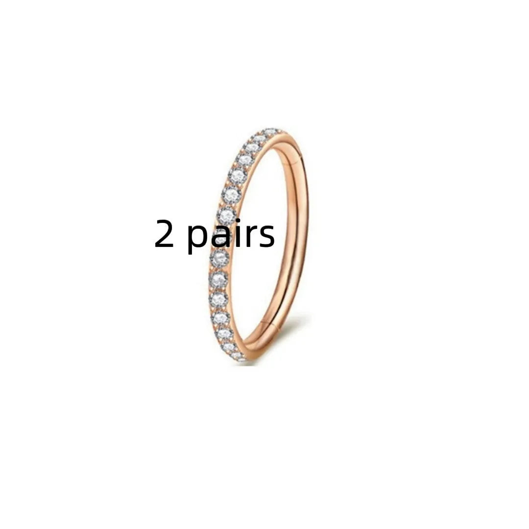 Two pairs of round, seamless 316 stainless steel nose rings showing black, gold, rose gold, and steel colour finishes.