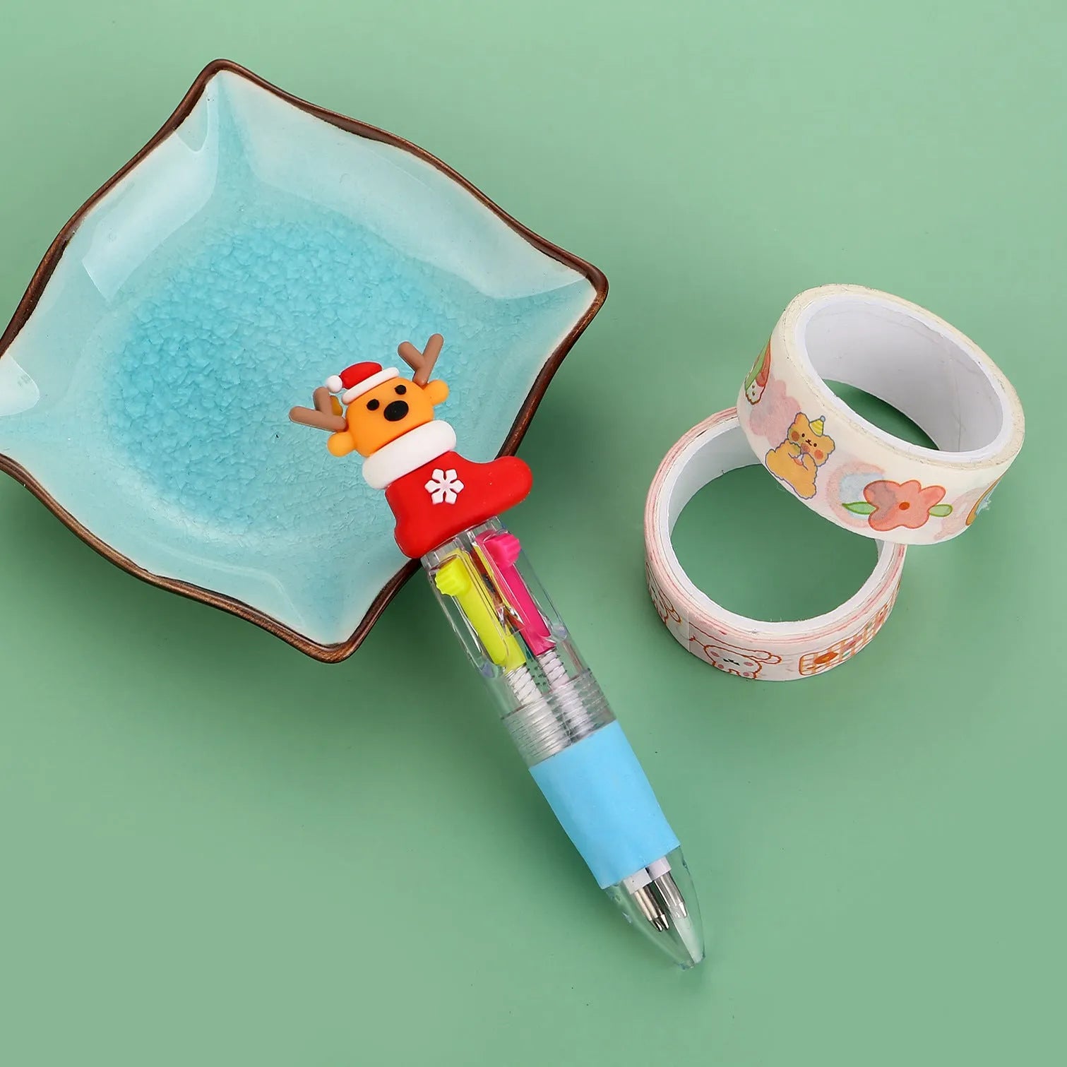 11cm long Christmas-themed four-colour ballpoint pen showing festive designs like reindeer and trees.