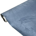 Roll of self-adhesive black leather suede fabric with adhesive backing visible, showing texture and a cut sheet sample.