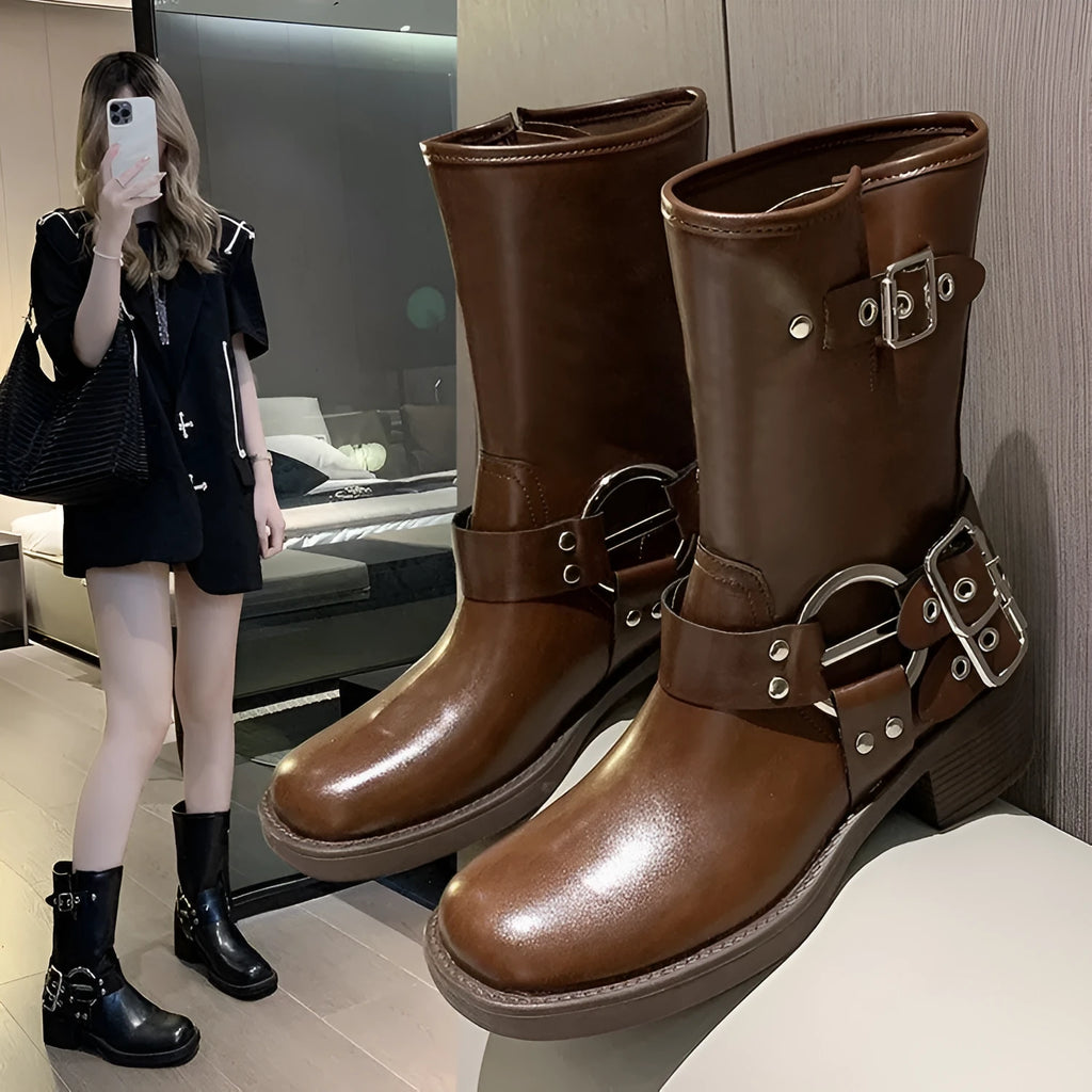 Women's black platform boots with belt buckle detail at mid-calf height