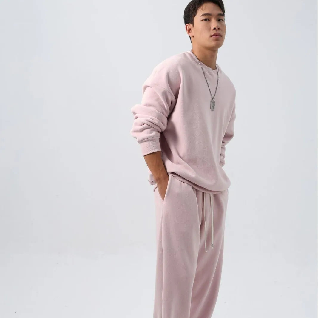 Men's black polar fleece sports suit with loose long sleeve coat and matching trousers on a hanger.