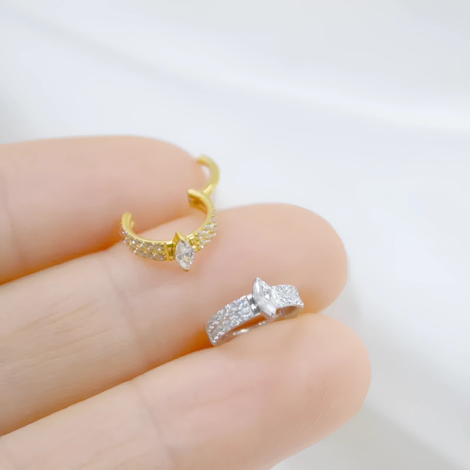 Close-up of a heart-shaped zircon diamond look earring in titanium steel, showing silver or gold colour on a 1.2x8mm setting.