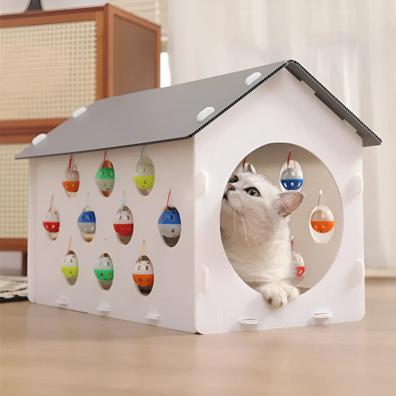 Plastic cat scratch board house with integrated tunnel containing bell ball and nest bed area