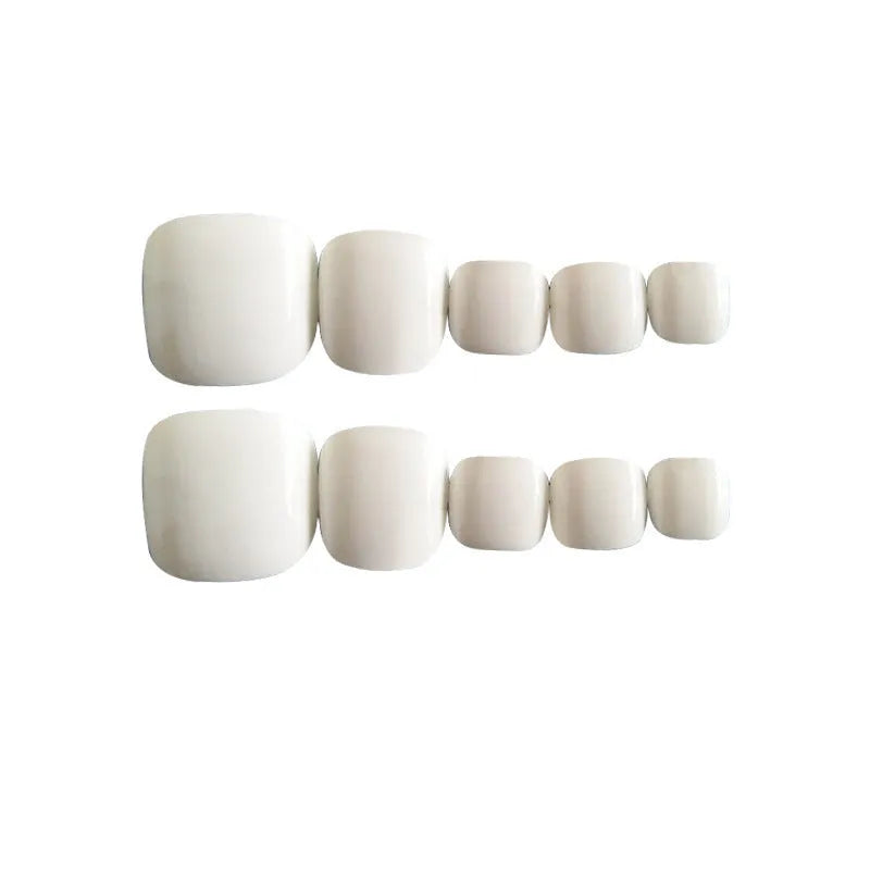 Set of white false toenails with a starry sky pattern and glue for application.