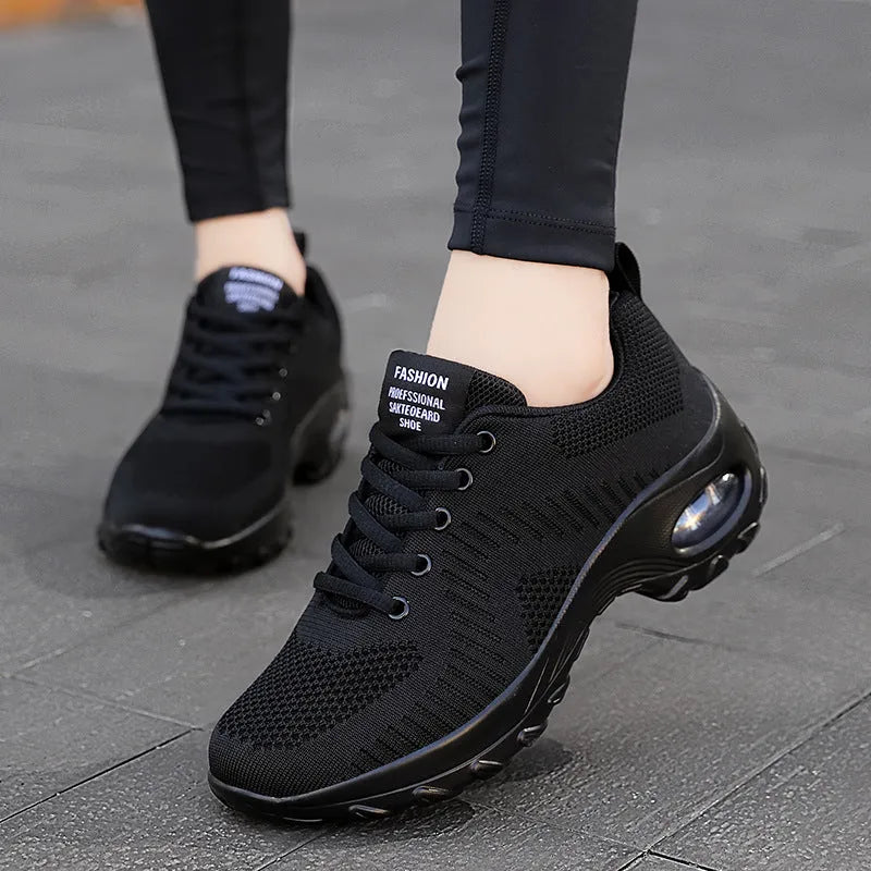Women's black mesh lace-up sneakers with round toe and mid heel on white background