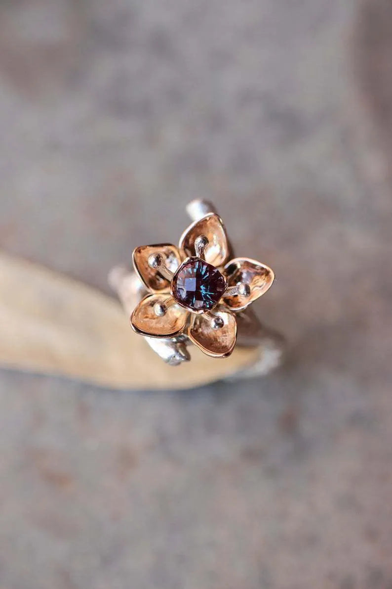 Silver two-tone floral geometric alloy ring for women on a grey background, showing detail.