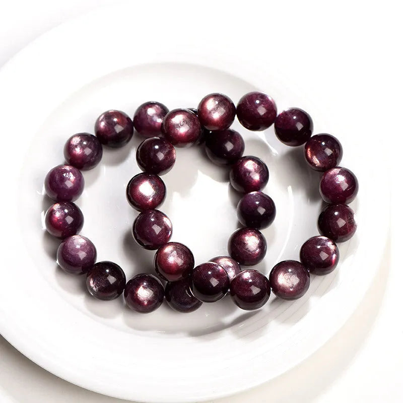 Close-up of a handcrafted purple lepidolite crystal bracelet with polished round beads on a wrist.