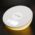 White wireless charger with digital clock display showing time and charging smartphone