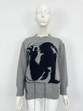 Grey women's loose alpaca wool sweater with abstract pattern and tassel design details on sleeve.