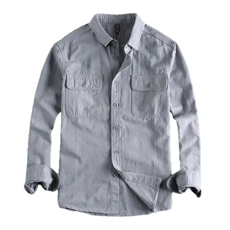 Man wearing a loose grey long sleeve shirt with a cardigan and overalls-inspired design