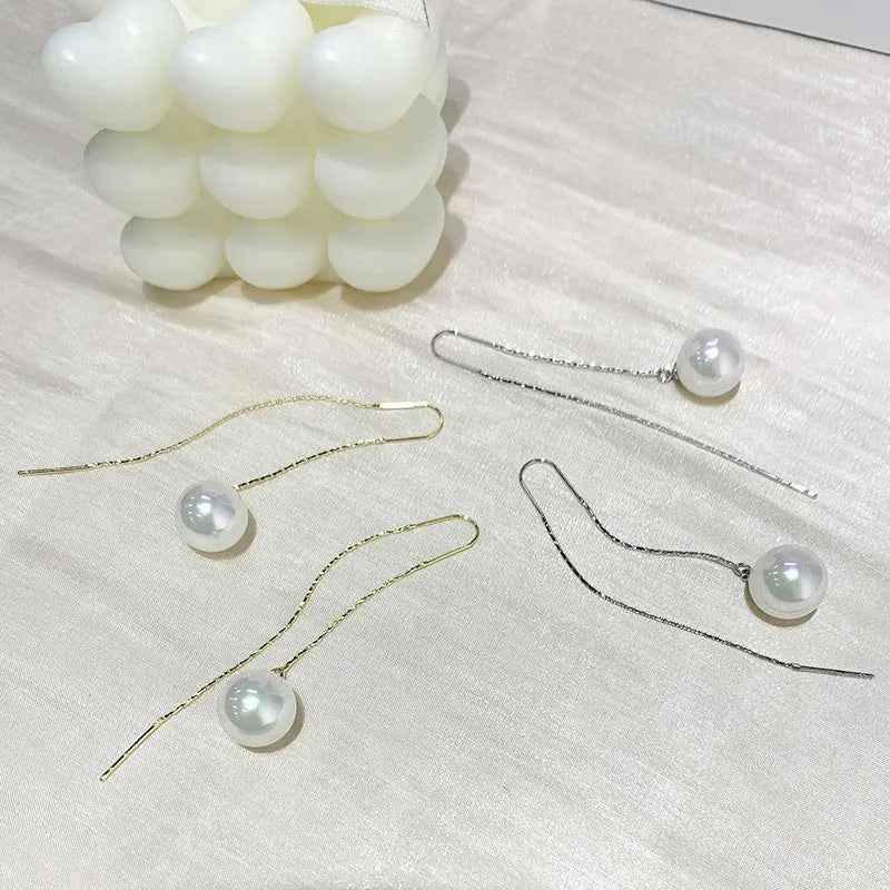 Fashionable long tassel pearl ear line drop earrings in gold finish on a white background