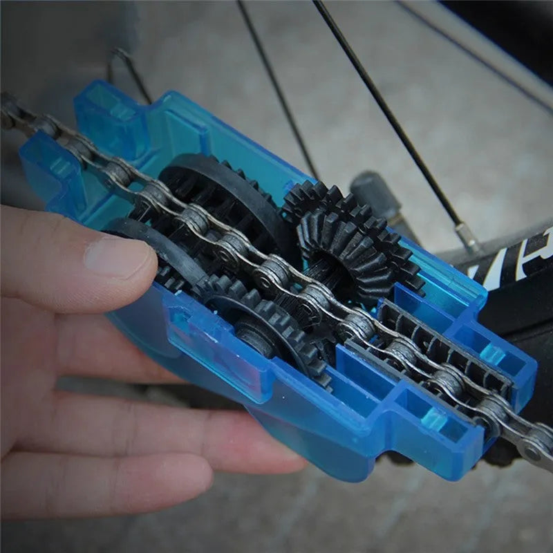 Blue plastic bicycle chain cleaning washer set with brushes on a bike chain