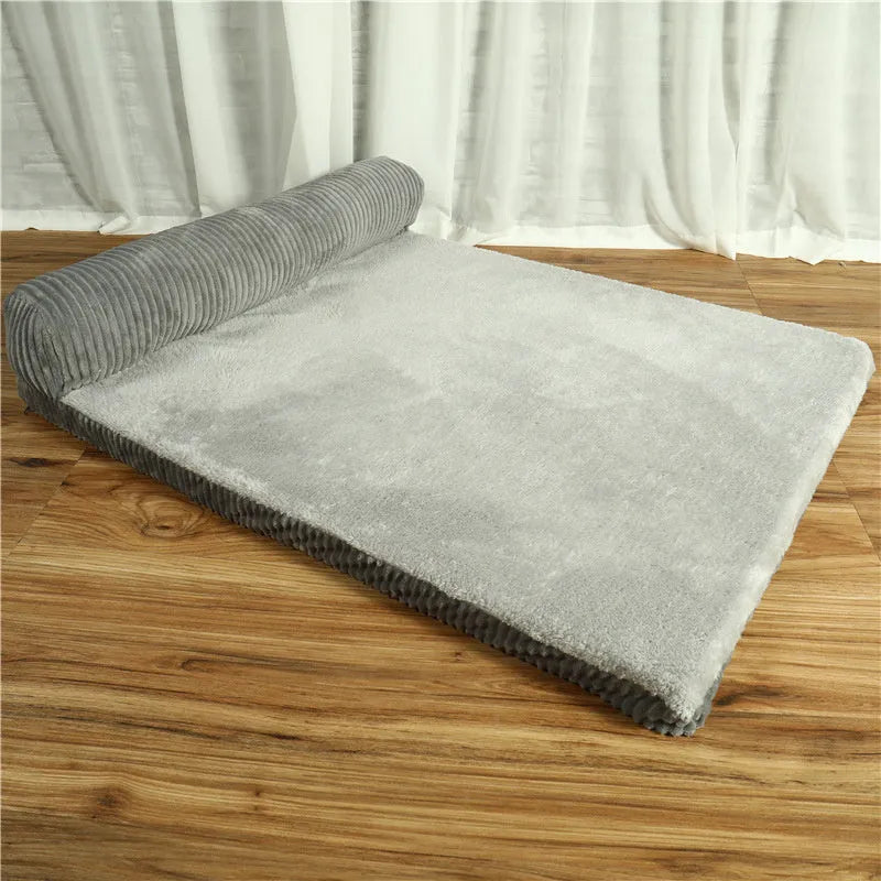 Corduroy pet sofa dog bed with bolster sides, shown in grey colour on a wooden floor