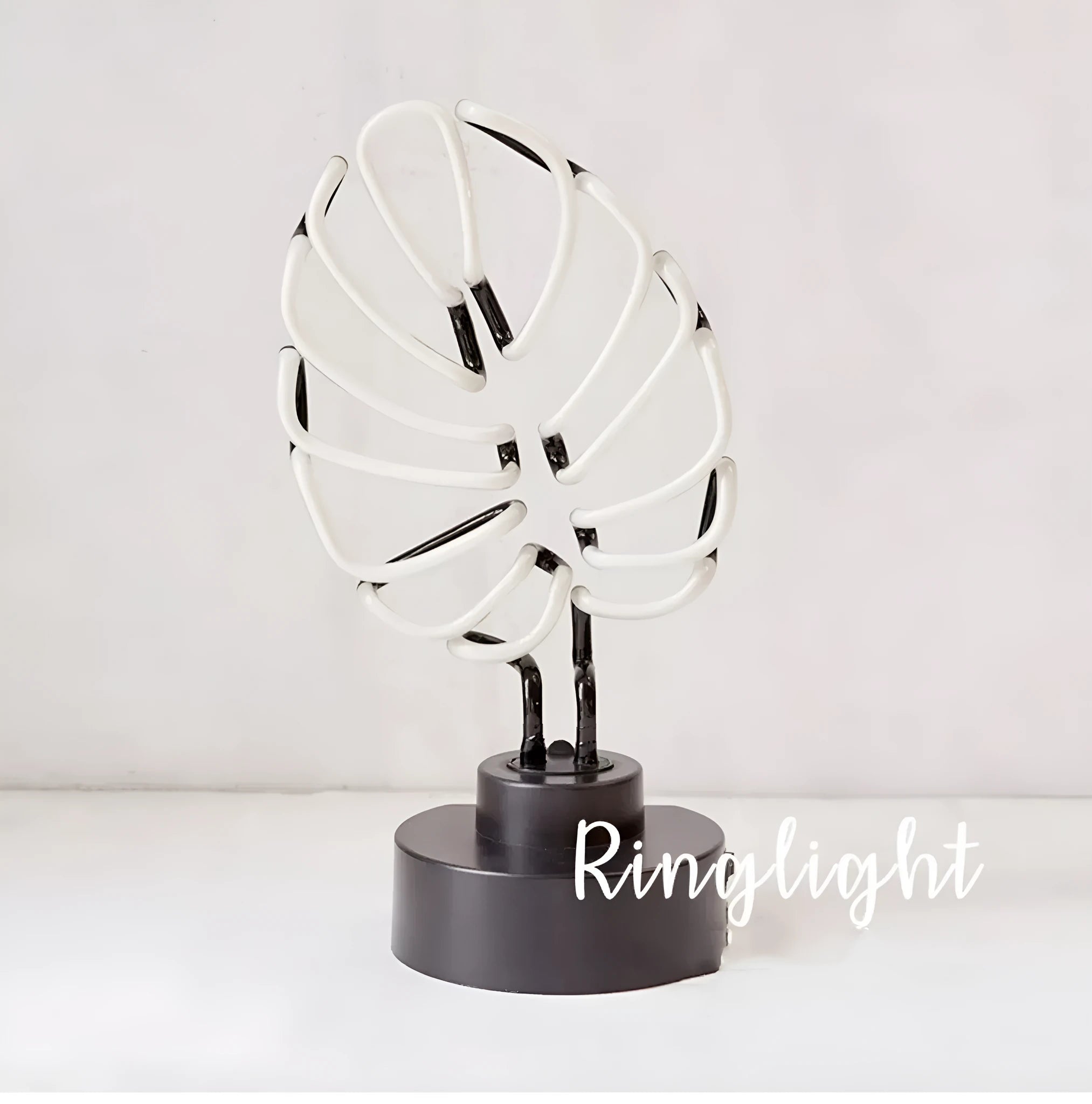White bamboo-shaped desktop lamp emitting green light with USB power cable