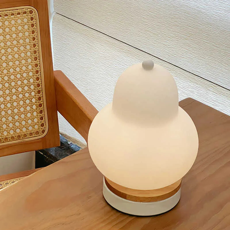 White pear rechargeable LED touch table lamp with PE shade on a bedside table